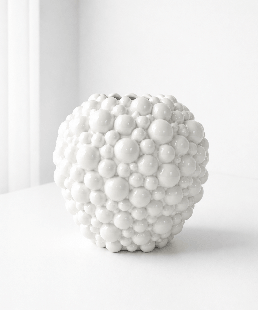 Weisse Keramikvase mit glänzendem Blasenmuster.