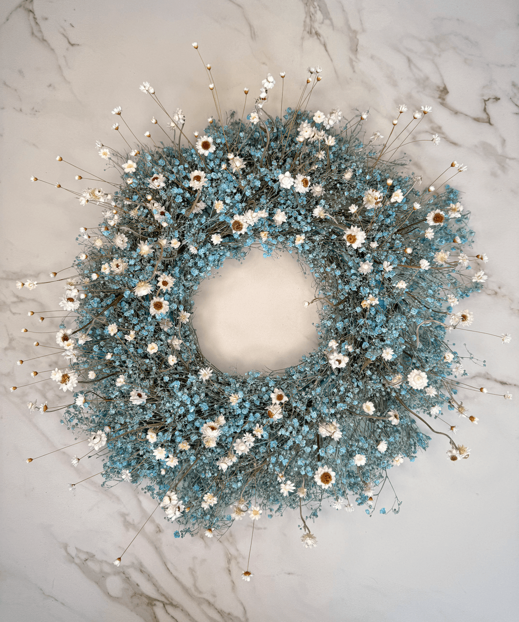 Trockenblumenkranz aus Blumen in Hellblau und Weiss.